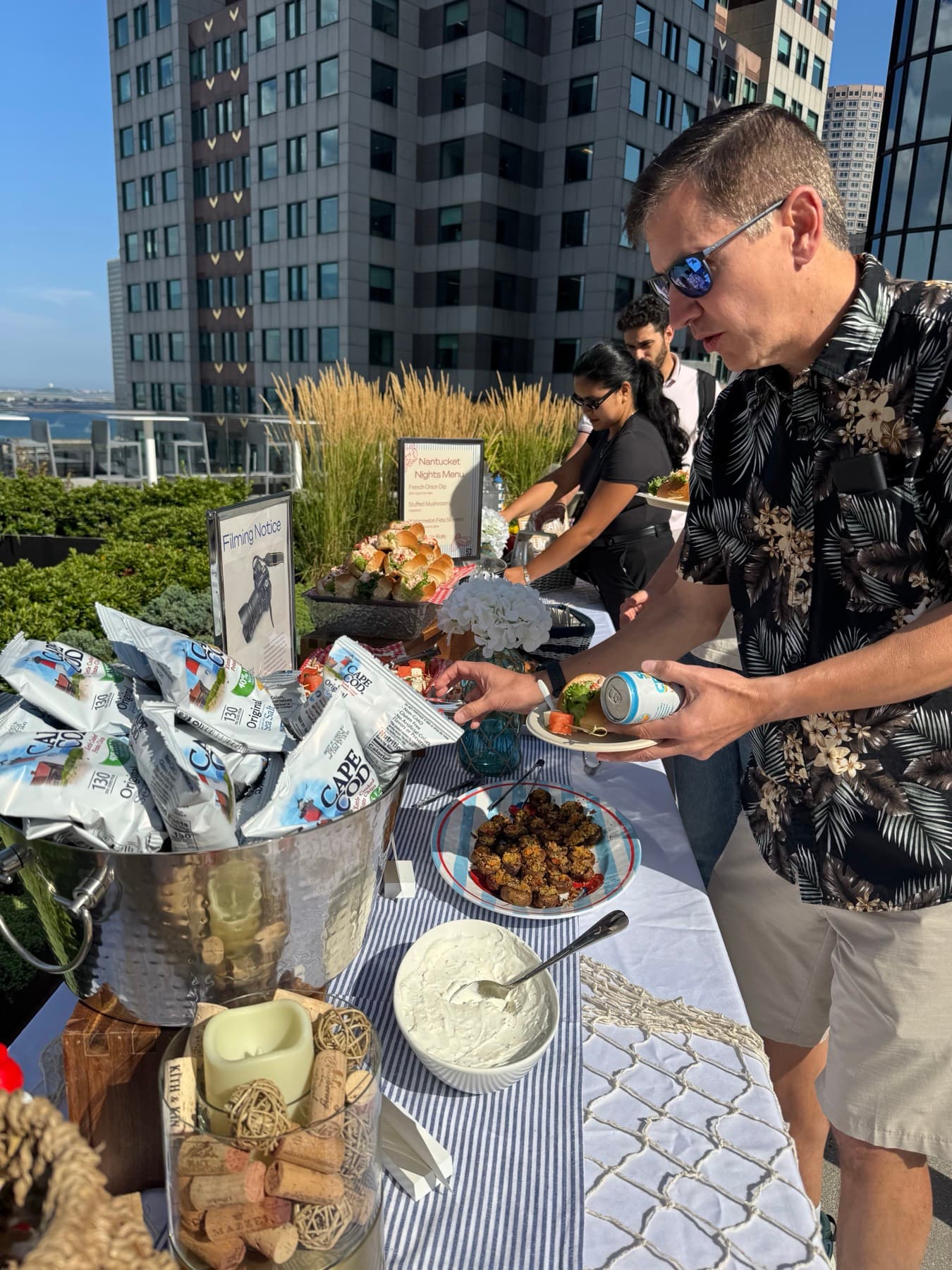 Tenants enjoying food and conversation at a rooftop building event